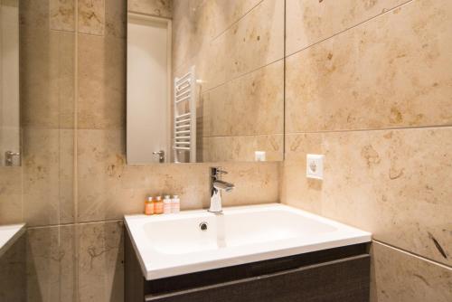 a bathroom with a white sink and a mirror at Apartments Grote Bickersstraat in Amsterdam