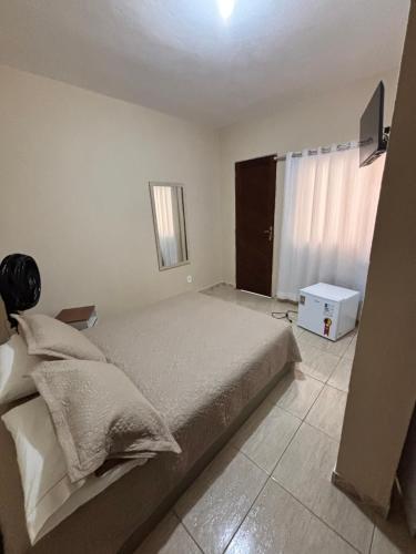 a bedroom with a large bed and a window at Suíte Aconchego 4 in Miguel Pereira