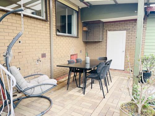 a patio with a black table and chairs at D142 Sunshine Designed Living in Sunshine