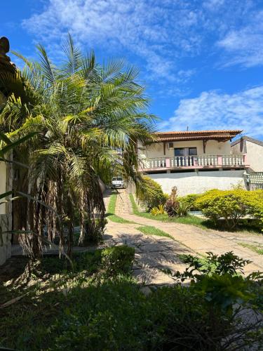 a house with a palm tree in front of it at Suíte Aconchego 4 in Miguel Pereira