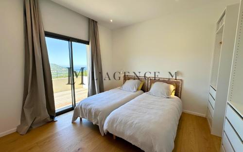 une chambre avec un lit et une grande fenêtre dans l'établissement Villa Giuliana Paisible & spacieuse AREGNO, à Aregno