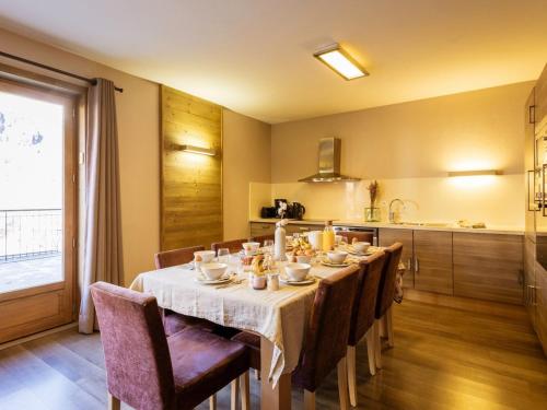 une salle à manger avec une table et des chaises et une cuisine dans l'établissement Charmant 4 pièces pour 8 pers. avec terrasse, proche télécabine à Valloire - FR-1-263-212, à Valloire