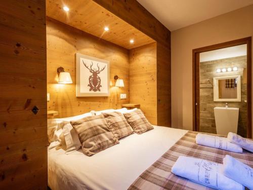 une chambre avec un lit dans un mur en bois dans l'établissement Charmant 4 pièces pour 8 pers. avec terrasse, proche télécabine à Valloire - FR-1-263-212, à Valloire