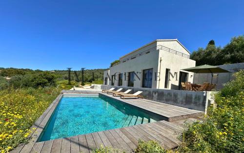 une maison avec une piscine à côté d'un bâtiment dans l'établissement Villa Giuliana Paisible & spacieuse AREGNO, à Aregno