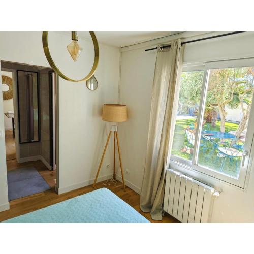 une chambre avec une fenêtre, une lampe et une table dans l'établissement Charme et Confort à Lagord, à Lagord