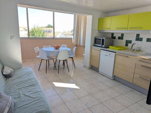 une cuisine et une salle à manger avec une table et des chaises dans l'établissement Appartement cosy avec piscine, proche commodités et plages, idéal pour familles - FR-1-387-164, à Marseillan