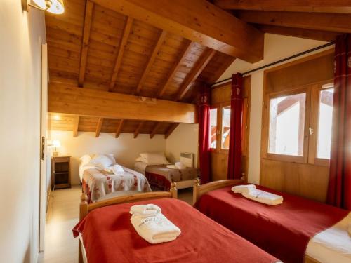 une chambre avec deux lits dans une pièce avec des plafonds en bois dans l'établissement Duplex 4 Pièces, Balcon, 8 Pers, 4*, Animaux OK, Proche Télécabine - Valloire - FR-1-263-207, à Valloire