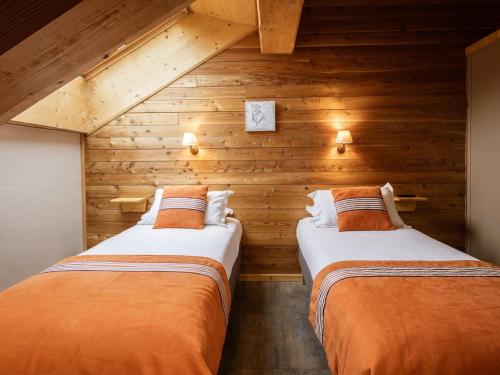 deux lits dans une chambre aux murs en bois dans l'établissement Appartement 3 pièces - 6 pers, 4* - Proche remontées et commerces, balcons, wifi, animaux bienvenus - FR-1-263-213, à Valloire