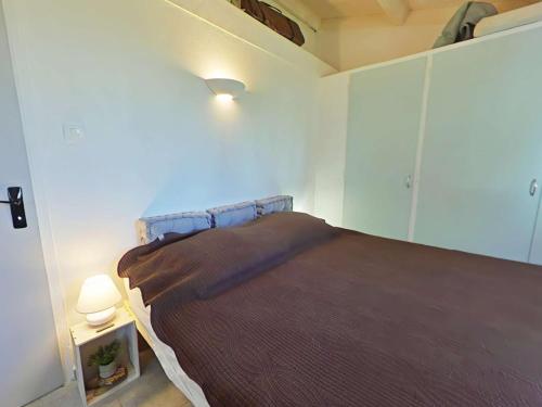 - une chambre avec un lit et une couverture brune dans l'établissement Maison 2 pièces avec mezzanine, piscine chauffée, proche mer, parking privé - Bretignolles-sur-Mer - FR-1-224A-7, à Bretignolles-sur-Mer