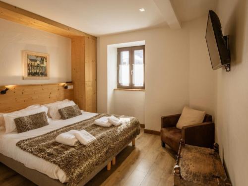 Un dormitorio con una cama y una silla y un televisor. en Appartement au cœur de Valloire, 6 pers, 3 chambres, balcon, proche ski et commerces - FR-1-263-363, en Valloire