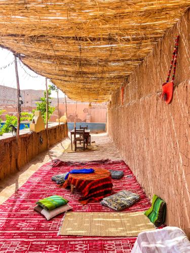 a room with a bed and a rug on a wall at Dar Toda - Zagora guest house in Zagora