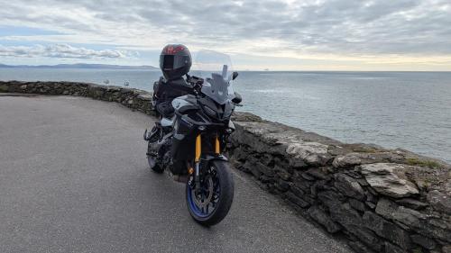 a person on a motorcycle parked next to the water at 1780 Green Street in Dingle