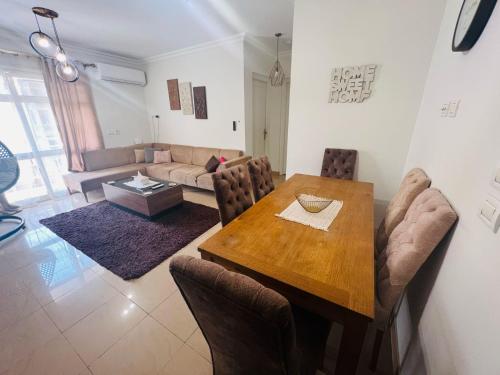 a dining room with a table and a couch at Cozy Modern Comfort-2 Bed Escape at Madinaty in Madinaty