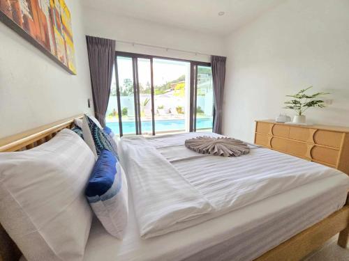 a large white bed in a bedroom with a window at Private villa near beach Koh Samui in Koh Samui