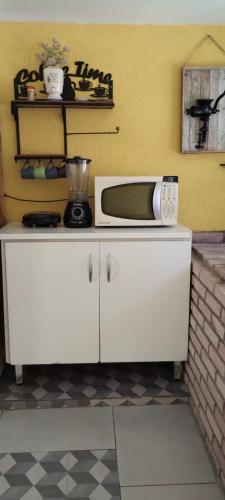 a microwave sitting on top of a kitchen counter at Sitio Oliveira Ibiuna in Ibiúna