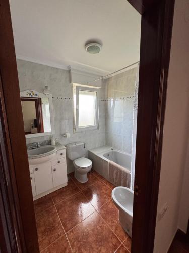 a bathroom with a tub and a toilet and a sink at Noja. Piso en noja a 5 minutos de la playa de Ris in Noja