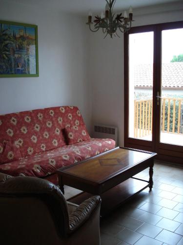 un salon avec un canapé rouge et une table basse dans l'établissement Maison de vacances 3 chambres 5 couchages 20 mn de la mer 34660 Cournonsec, à Cournonsec