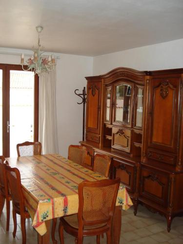 d'une salle à manger avec une table et une armoire en bois. dans l'établissement Maison de vacances 3 chambres 5 couchages 20 mn de la mer 34660 Cournonsec, à Cournonsec