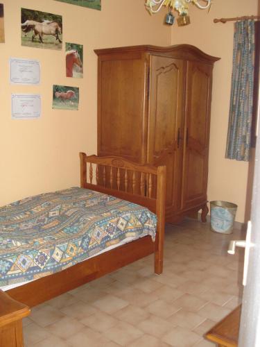 une chambre avec un lit et une armoire en bois dans l'établissement Maison de vacances 3 chambres 5 couchages 20 mn de la mer 34660 Cournonsec, à Cournonsec