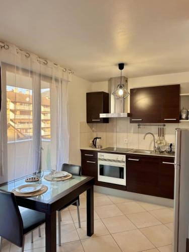 Il comprend une cuisine équipée d'une table à manger et d'un réfrigérateur. dans l'établissement Annecy cozy studio with terrace, à Annecy
