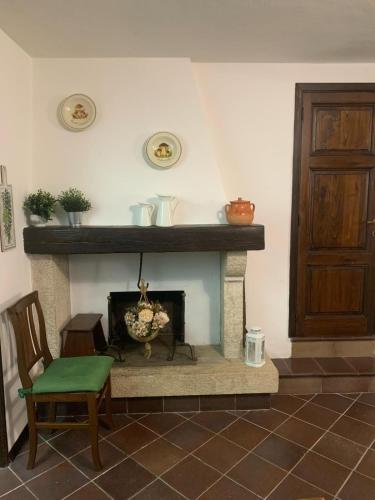 a living room with a fireplace with a green chair at Casa Maria Saturnia in Saturnia