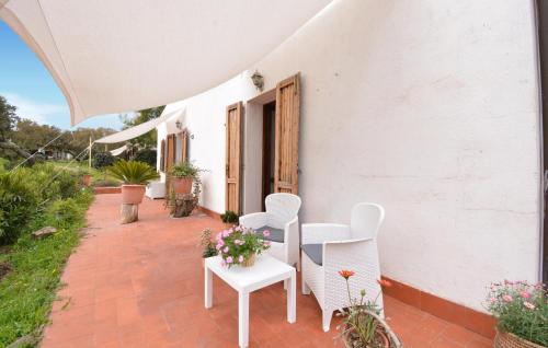 a patio with white chairs and a table with flowers at Gorgeous Home In Sedini With Wifi in Sedini