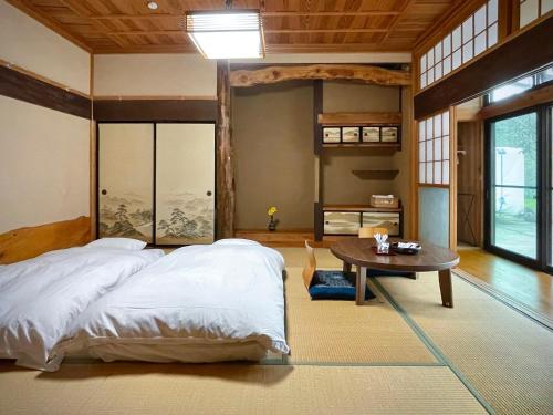 a bedroom with a large bed and a table at 白華の家 House of Hakka秋田駅秋田空港への送迎可能 in Akita