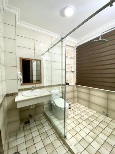 a bathroom with a toilet and a sink and a shower at Lucasta Hotel in Can Tho