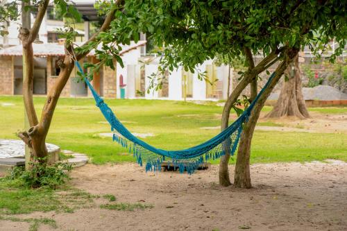 a blue hammock hanging between two trees in a park at Vila Iriri - Pousada e Camping in Anchieta