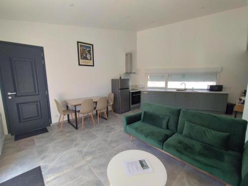 a living room with a green couch and a table at Maison individuelle centre ville "TIMAJO" in Bapaume