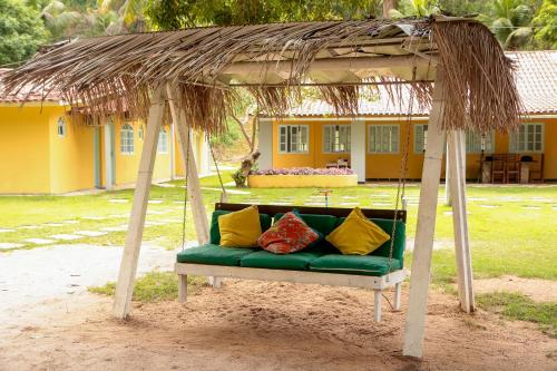 a swing with pillows on it in front of a house at Vila Iriri - Pousada e Camping in Anchieta