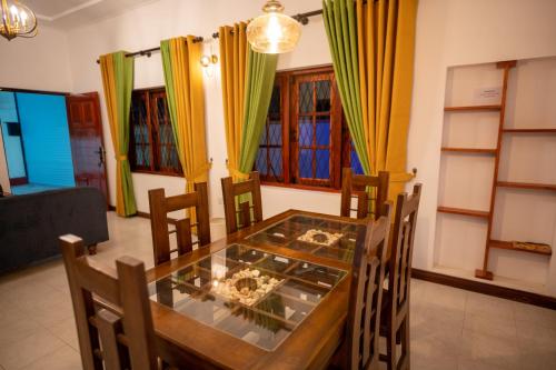 a dining room with a glass table and chairs at Carmel Crown Villa in Hatton