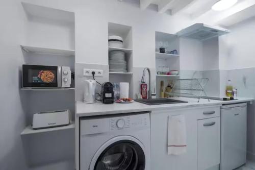 une cuisine blanche avec une machine à laver à l'intérieur dans l'établissement Appartement Popincourt Bastille, à Paris