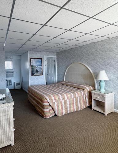 a bedroom with a large bed and a table at The Jetty Motel in Cape May