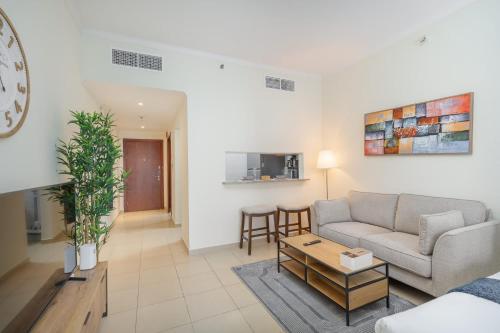 ein Wohnzimmer mit einer Couch und einem Tisch in der Unterkunft Prime Studio in Jumeirah Bay X1 in JLT - Sleeps 2 in Dubai