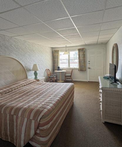 a hotel room with a large bed and a desk at The Jetty Motel in Cape May