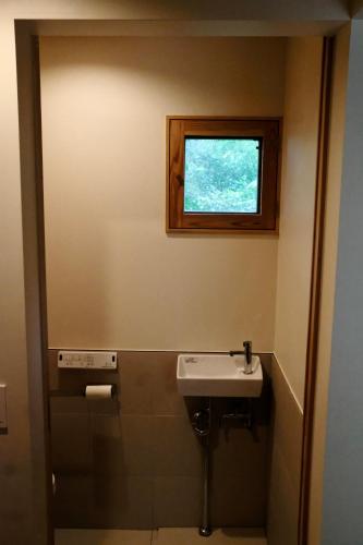 a bathroom with a sink and a window at Bridgebuilders Tourist Home in Nanjo