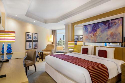 a hotel room with a large bed and a desk at Gulf Hotel Bahrain Convention and SPA in Manama