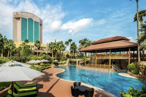 a pool at a resort with a building in the background at Gulf Hotel Bahrain Convention and SPA in Manama