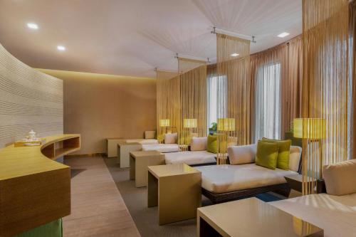 a waiting room with couches and chairs and tables at Gulf Hotel Bahrain Convention and SPA in Manama
