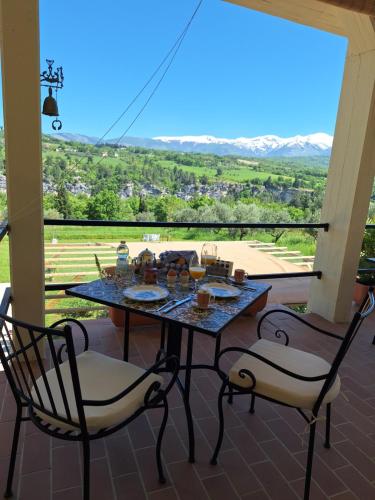a table and two chairs on a porch with a view at Villa Vista Monti in Bolognano