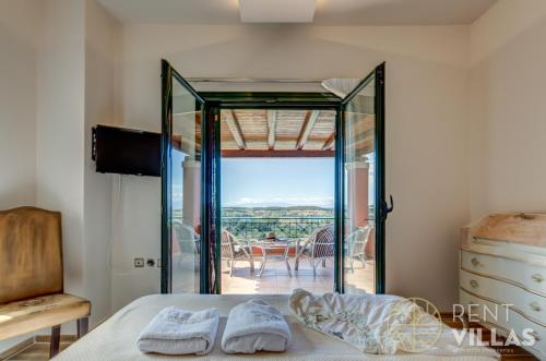 a bedroom with a glass door leading to a patio at Mariza Luxury Villa With Pool by goutos properties in Porto Heli