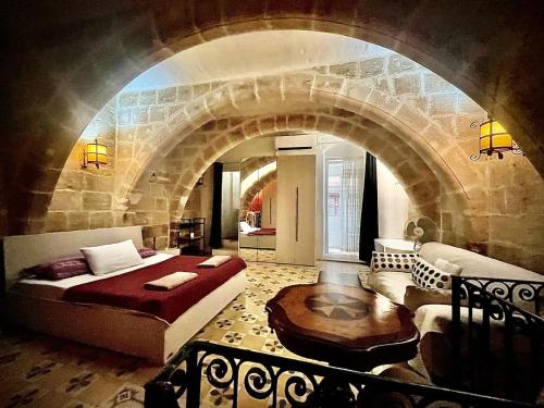 a bedroom with a bed and a stone wall at 300 years old Maisonette in Beautiful Stairs in Valletta
