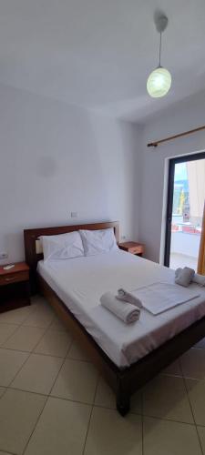 a bedroom with a bed with two towels on it at 2 Palmat Hotel in Ksamil