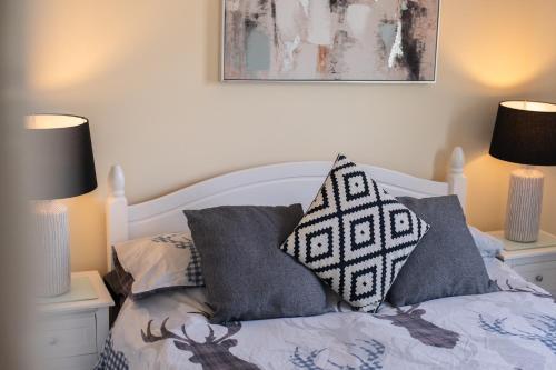 a bedroom with a bed with pillows and two lamps at Inverness Holiday Retreat - 2 Bedroom in Inverness