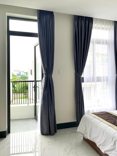 a bedroom with a bed and a large window at Lucasta Hotel in Can Tho
