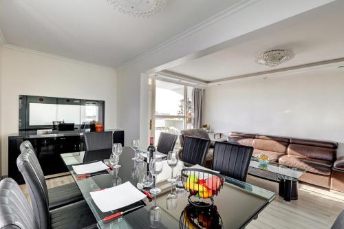 une salle à manger avec une table et des chaises en verre dans l'établissement 100m2, Appartement Moderne et Luxueux 6 personnes, à Bagnolet