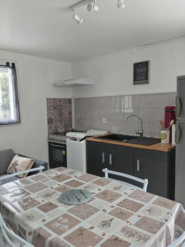 Il comprend une cuisine avec une table et un évier. dans l'établissement Location saisonniere, à Cozes