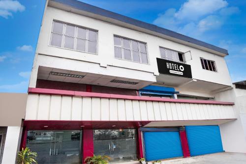 a white building with blue and red doors at Super Hotel O Krishna Nagar Chowk Near ONGC in Dehradun