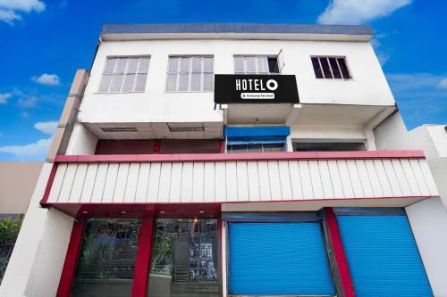 a white building with a sign on it at Super Hotel O Krishna Nagar Chowk Near ONGC in Dehradun